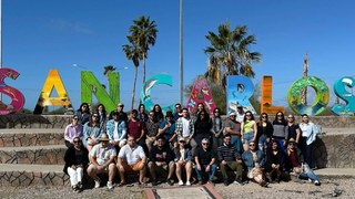Group photo of colloquium participants at the San Carlos sign, Sonora.